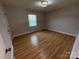 A bedroom features wood floors, window and light fixture at 396 Pitts School Nw Rd, Concord, NC 28027