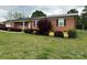 Charming brick home with a black metal roof and well-manicured landscaping at 396 Pitts School Nw Rd, Concord, NC 28027