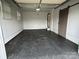 View of the garage with a speckled floor and sliding door on the right side at 396 Pitts School Nw Rd, Concord, NC 28027