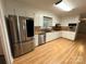 Well-lit kitchen showcasing stainless steel appliances and sleek white cabinetry at 396 Pitts School Nw Rd, Concord, NC 28027