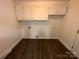 Laundry room with wood floors and white cabinetry at 396 Pitts School Nw Rd, Concord, NC 28027