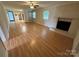 Open living room featuring a brick fireplace and wood flooring at 396 Pitts School Nw Rd, Concord, NC 28027