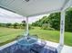 Relaxing covered back porch with views of the expansive lawn and a tranquil pond at 4008 Houndscroft Rd, Indian Trail, NC 28079