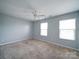 Spacious bedroom with neutral carpet, a ceiling fan, and natural light from two large windows at 4008 Houndscroft Rd, Indian Trail, NC 28079