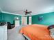 A colorful bedroom featuring orange bedding, turquoise walls, and plush carpeting at 4008 Houndscroft Rd, Indian Trail, NC 28079