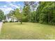 Expansive backyard features a lush green lawn and wooded area, offering privacy and space at 406 Brentwood Cir, Kannapolis, NC 28081