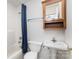 Compact bathroom features a toilet, pedestal sink, and a tub with a blue shower curtain at 406 Brentwood Cir, Kannapolis, NC 28081