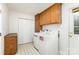 Functional laundry room features overhead cabinets, folding station, and patterned flooring at 406 Brentwood Cir, Kannapolis, NC 28081