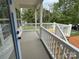 Covered back porch with white railing overlooking a spacious backyard with a wooden staircase at 418 W Westview St, Gastonia, NC 28052