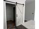 Whitewashed wooden sliding barn door with black hardware, showcasing access to another room at 418 W Westview St, Gastonia, NC 28052