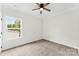 Bright bedroom with carpet, fan, and a view of the yard through the window at 418 W Westview St, Gastonia, NC 28052