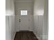 A bright foyer with white walls, wainscoting, a white door with glass panels, and dark wood flooring at 418 W Westview St, Gastonia, NC 28052