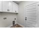 Neat laundry room features storage cabinets, brick flooring, and a white door at 418 W Westview St, Gastonia, NC 28052