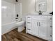 Bathroom featuring white vanity, black hardware, white toilet, tub, and wood-look flooring at 420 Fulton Dr, Kings Mountain, NC 28086