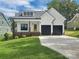 Charming two-story home with a well-manicured lawn, black garage doors, and a welcoming yellow front door at 420 Fulton Dr, Kings Mountain, NC 28086