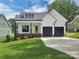Charming two-story home with a well-manicured lawn, black garage doors, and a welcoming yellow front door at 420 Fulton Dr, Kings Mountain, NC 28086