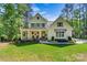 Beautiful exterior of home featuring a covered front porch and lush green lawn and mature trees at 4290 Palm Dr, Denver, NC 28037