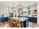 Open kitchen with blue island, stainless steel appliances, and white cabinets and dining seating at 4290 Palm Dr, Denver, NC 28037