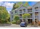 Charming condo with balconies, complemented by well-maintained landscaping and a blue car parked nearby at 430 Queens Rd # 111, Charlotte, NC 28207