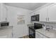 Kitchen with white cabinets, grey countertops, and black appliances at 430 Queens Rd # 111, Charlotte, NC 28207