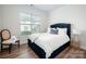 Cozy bedroom featuring a stylish blue headboard, bright natural light, and sleek hardwood floors at 4312 Plumeria Way, Fort Mill, SC 29707