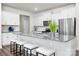 Stylish kitchen island with granite countertop, seating, stainless appliances, and white cabinetry at 4312 Plumeria Way, Fort Mill, SC 29707
