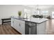Bright kitchen island with stainless dishwasher, granite countertops, and open view to dining area at 4312 Plumeria Way, Fort Mill, SC 29707