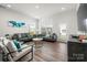 This cozy living room features a plush grey sofa, modern armchairs, and bright natural light at 4312 Plumeria Way, Fort Mill, SC 29707