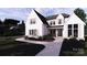Stunning two-story modern farmhouse exterior with light gray pathway and lush landscaping at 4609 Firethorn Ct, Denver, NC 28037
