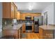 Well-lit kitchen with stainless steel appliances, wood cabinets, and tile backsplash at 4927 Gateway Dr, Claremont, NC 28610