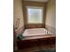 Relaxing bathroom showcasing a large soaking tub with tiled surround and under-cabinet storage at 506 E Pine St, Maiden, NC 28650