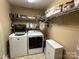 Functional laundry room equipped with a modern washer, dryer, and shelving for organized storage at 506 E Pine St, Maiden, NC 28650