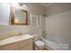 Bathroom featuring tub with shower, wainscoting, and built in shelves at 6007 Kenmore Ln, Indian Trail, NC 28079