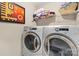 Bright laundry room with washer, dryer, wire shelving, and framed art print at 6041 Laurent Ave, Fort Mill, SC 29715
