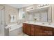 Main bathroom featuring double sinks, a soaking tub, and natural light at 6041 Laurent Ave, Fort Mill, SC 29715