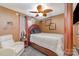 Bedroom with neutral tones, a wooden four-poster bed, soft carpeting, and unique ceiling fan at 636 Sadler Glen Dr, Charlotte, NC 28214