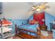 Blue bedroom featuring wooden furniture, red accents, a ceiling fan, and unique decor elements at 636 Sadler Glen Dr, Charlotte, NC 28214