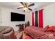 Bedroom features red and black curtains, a bed with red patterned bedding, and a large television at 636 Sadler Glen Dr, Charlotte, NC 28214