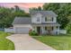 Charming two-story traditional home with inviting front porch and manicured lawn on a landscaped lot at 636 Sadler Glen Dr, Charlotte, NC 28214