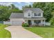 Charming two-story traditional home with inviting front porch and manicured lawn on a landscaped lot at 636 Sadler Glen Dr, Charlotte, NC 28214
