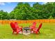 Lush backyard featuring green grass, a wooden fence, and a cozy firepit seating area at 6713 Edwards Farm Ln, Monroe, NC 28110