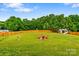 Sprawling backyard featuring green grass, a wooden fence, and a cozy firepit seating area at 6713 Edwards Farm Ln, Monroe, NC 28110