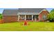 Spacious backyard with a covered patio, fire pit, and manicured lawn, perfect for outdoor living at 6713 Edwards Farm Ln, Monroe, NC 28110