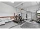 Finished basement featuring workout equipment, a lounge area, and a three-car garage door at 6713 Edwards Farm Ln, Monroe, NC 28110