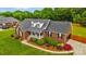 Charming brick home with lush landscaping, mature trees, and a well-manicured lawn at 6713 Edwards Farm Ln, Monroe, NC 28110