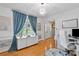 Bright home office features modern decor, hardwood floors, and a large window with blue curtains at 6713 Edwards Farm Ln, Monroe, NC 28110
