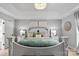 Relaxing primary bedroom with tray ceiling features a decorative chandelier and a luxurious bed at 6713 Edwards Farm Ln, Monroe, NC 28110