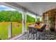 Inviting covered patio featuring a dining area overlooking a lush green backyard at 6713 Edwards Farm Ln, Monroe, NC 28110