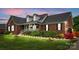 Charming brick home with manicured lawn, dormers, and inviting front porch with decorative shrubbery at 6713 Edwards Farm Ln, Monroe, NC 28110
