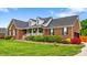 Charming brick home with manicured lawn, dormers, and inviting front porch with decorative shrubbery at 6713 Edwards Farm Ln, Monroe, NC 28110